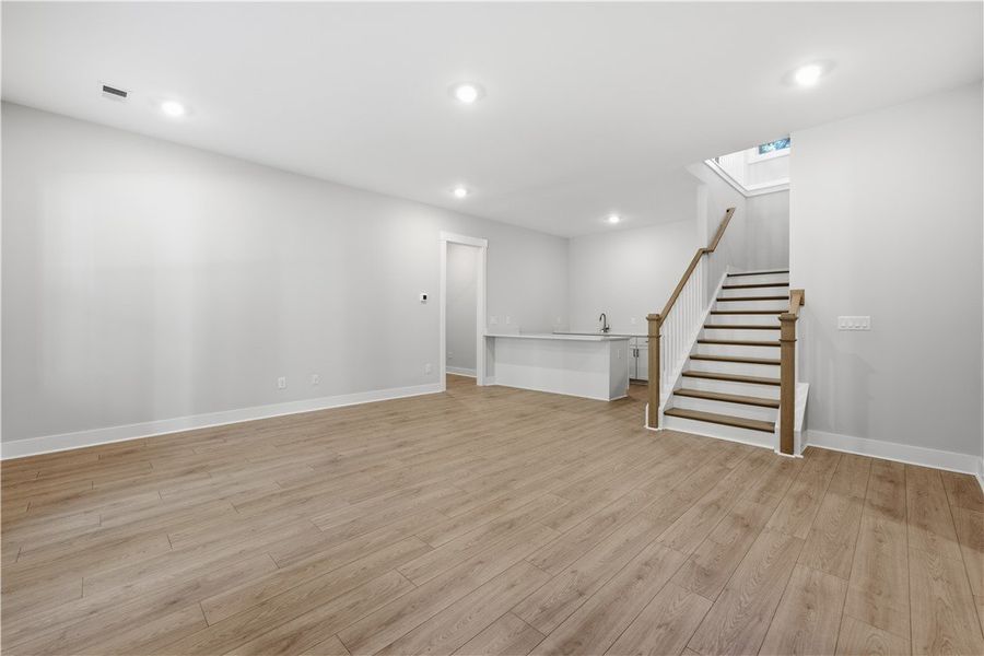 Smooth wood floors anchor this open lower level la