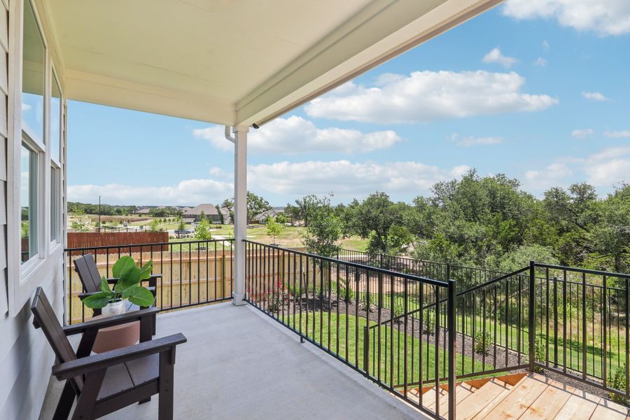 A deck with a railing and trees. A deck with a railing and trees.