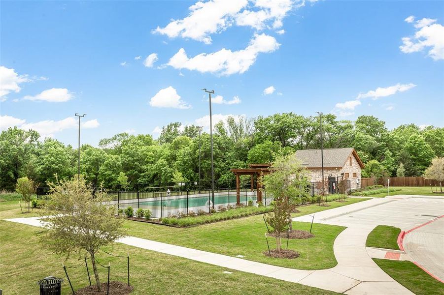 This property features a swimming pool with a surrounding fence, a stone-clad building with a gabled roof, and a paved pathway