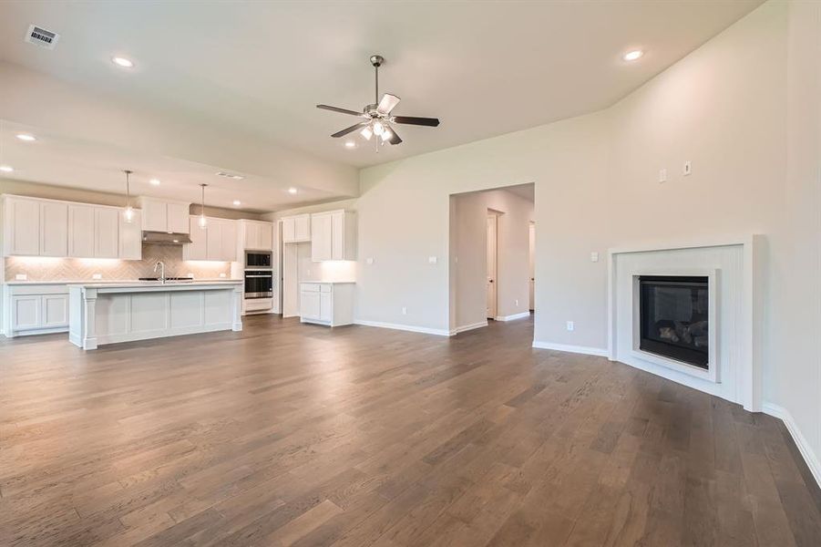 Unfurnished living room with dark hardwood / wood-style floors, ceiling fan, and sink