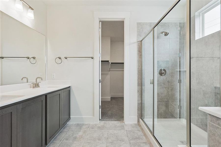 Bathroom featuring an enclosed shower, vanity, and tile patterned floors