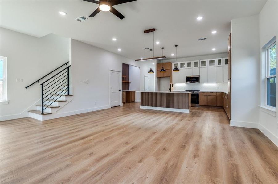 Kitchen with plenty of natural light, open floor plan, pendant lighting, an island with sink, and recessed lighting