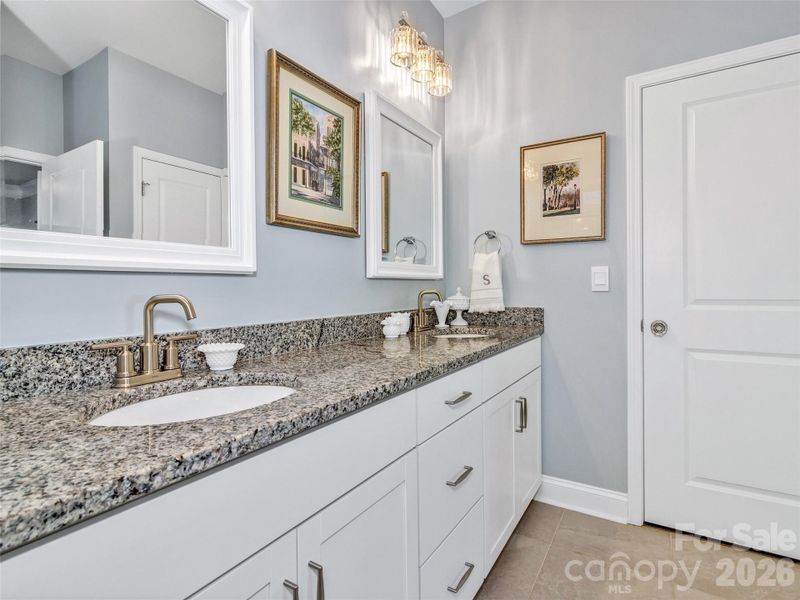 Double vanity with grey granite countertop.