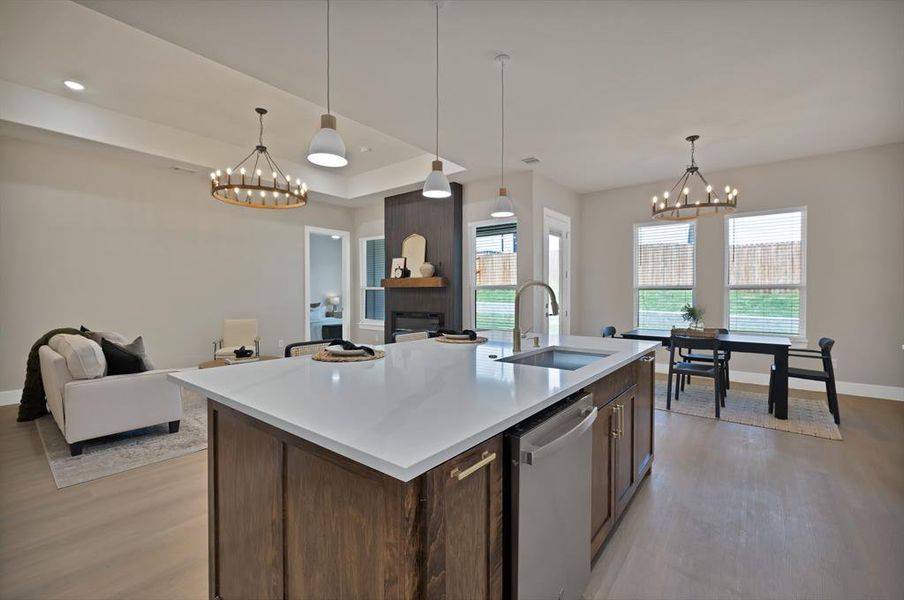Kitchen featuring a sink, a chandelier, dishwasher, and light wood finished floors