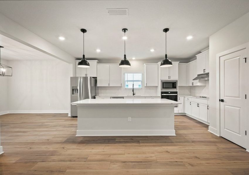 Kitchen with white cabinets and quartz countrtops.