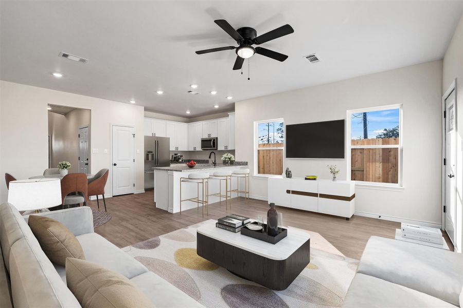 Virtually staged living room showcasing the open-concept layout, abundant natural light, and durable vinyl plank flooring, highlighting the flexibility and scale of the space.