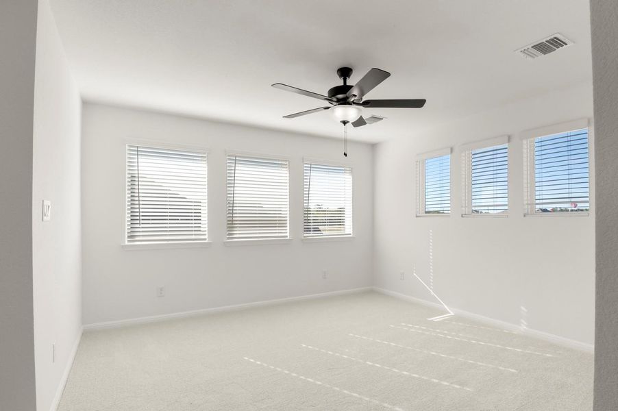 Empty room with light colored carpet and ceiling fan