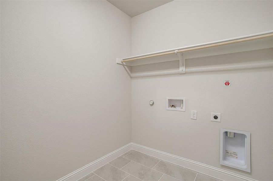 Washroom with washer hookup, light tile patterned floors, electric dryer hookup, and hookup for a gas dryer