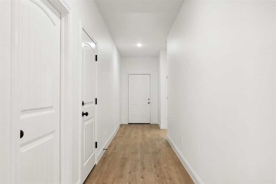 Corridor with light hardwood / wood-style flooring