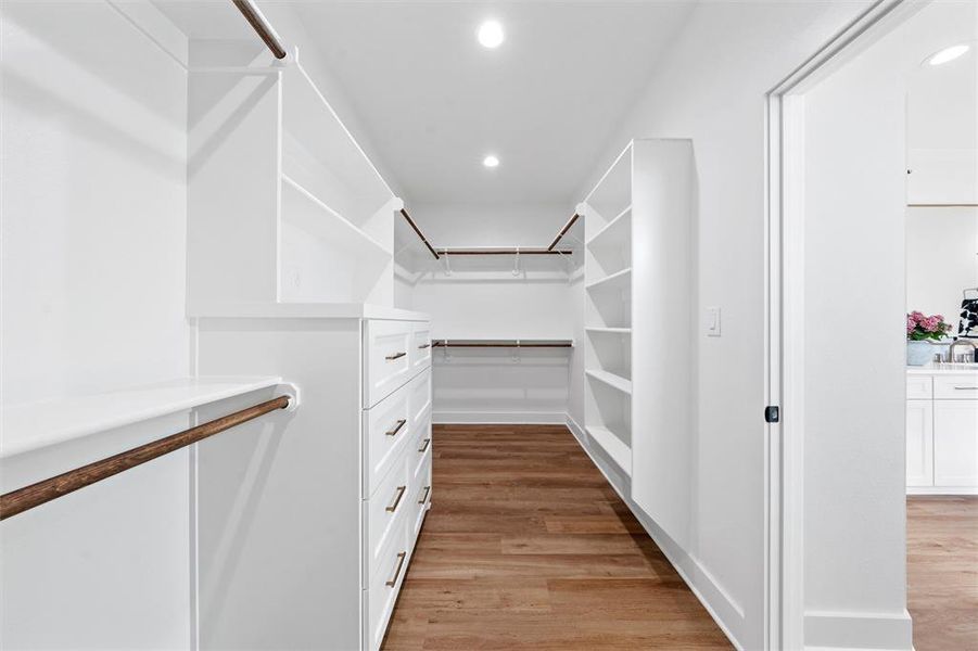 Walk in closet with light wood-type flooring and a sink