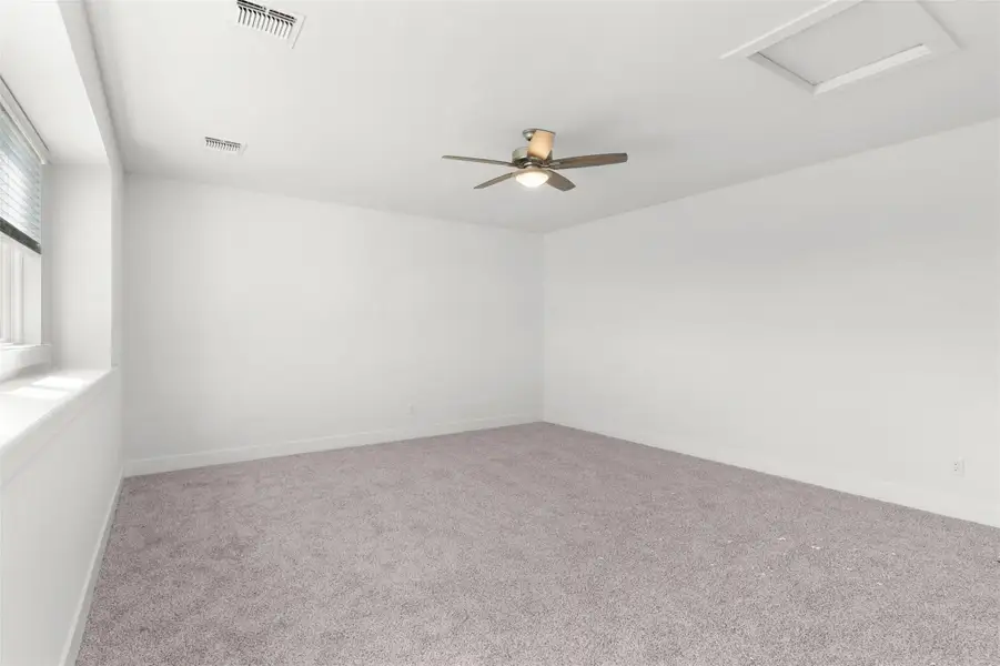 Spare room featuring light carpet and attic access