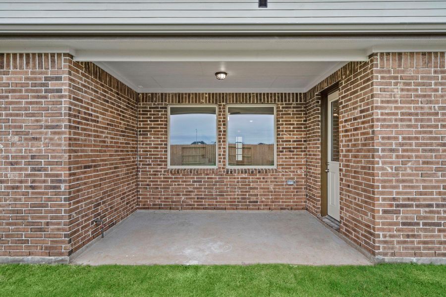 The covered patio is generously sized, providing ample space for various outdoor activities.
