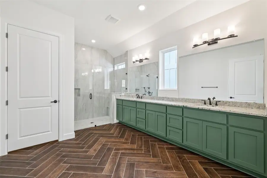 Bathroom with a shower stall, double vanity, and recessed lighting