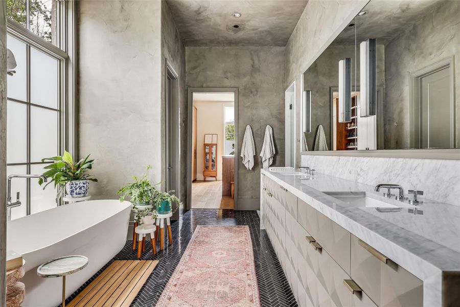 The primary bathroom provides a deep soaking tub and an extended marble vanity with dual sinks.