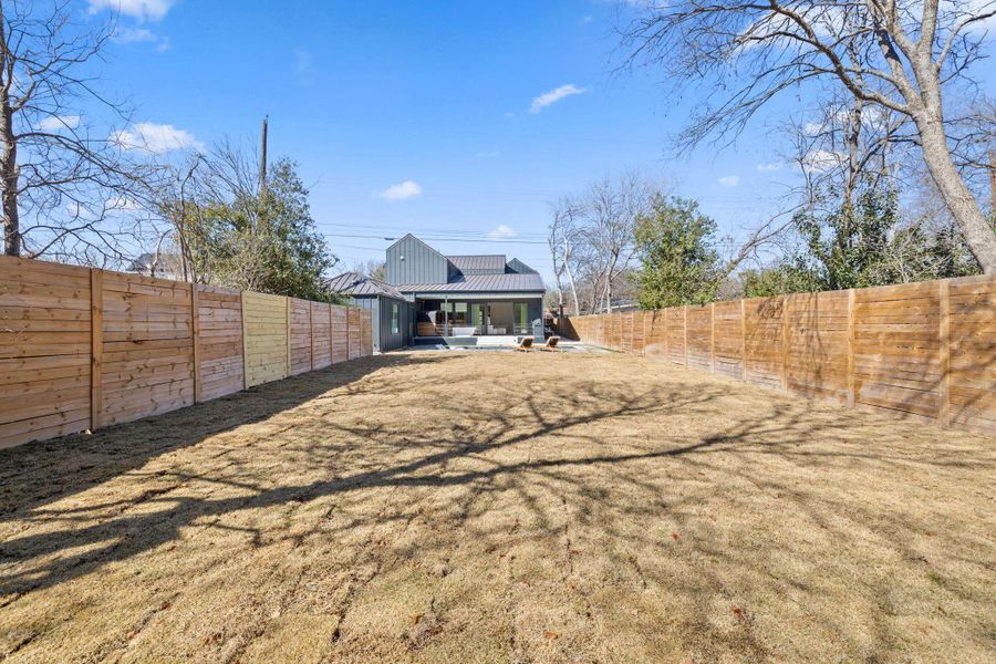 Back of property with a patio area, a fenced backyard, and a metal roof
