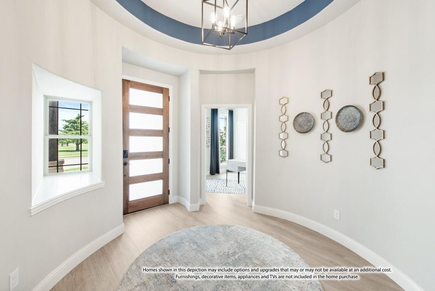 Round foyer with tray ceiling, wood front door, pendant light, and light hardwood floors Round foyer with tray ceiling, wood front door, pendant light, and light hardwood floors