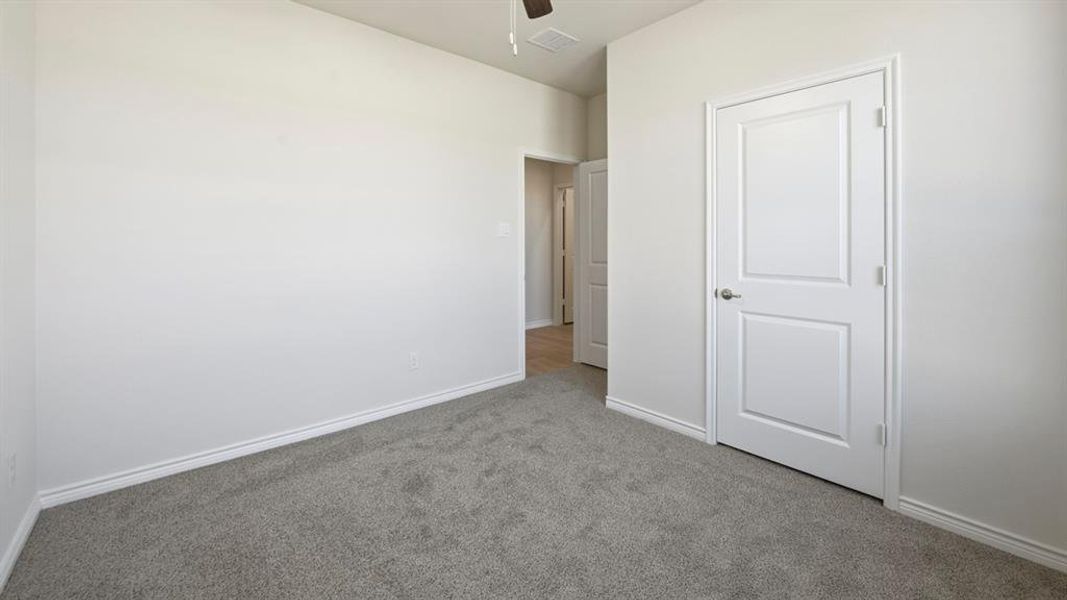 Unfurnished bedroom with carpet floors and a ceiling fan