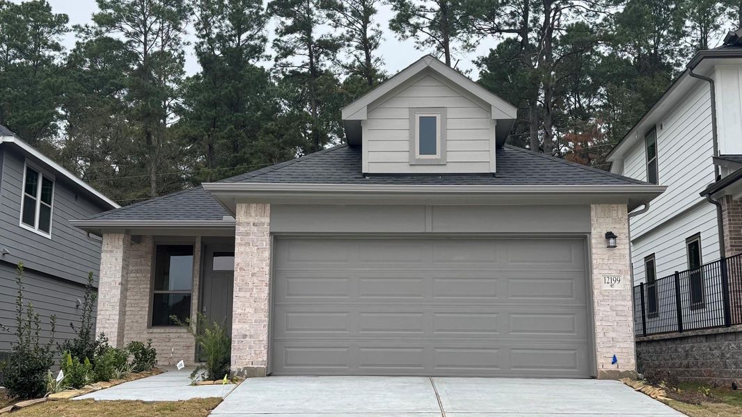 Front exterior of a new home in Westridge Cove, Conroe, TX, highlighting curb appeal (Image 1).