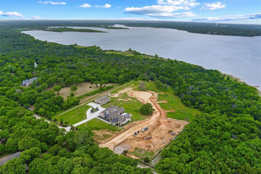 Expansive land parcel with direct lake frontage, featuring a newly constructed residence and a detached structure Expansive land parcel with direct lake frontage, featuring a newly constructed residence and a detached structure