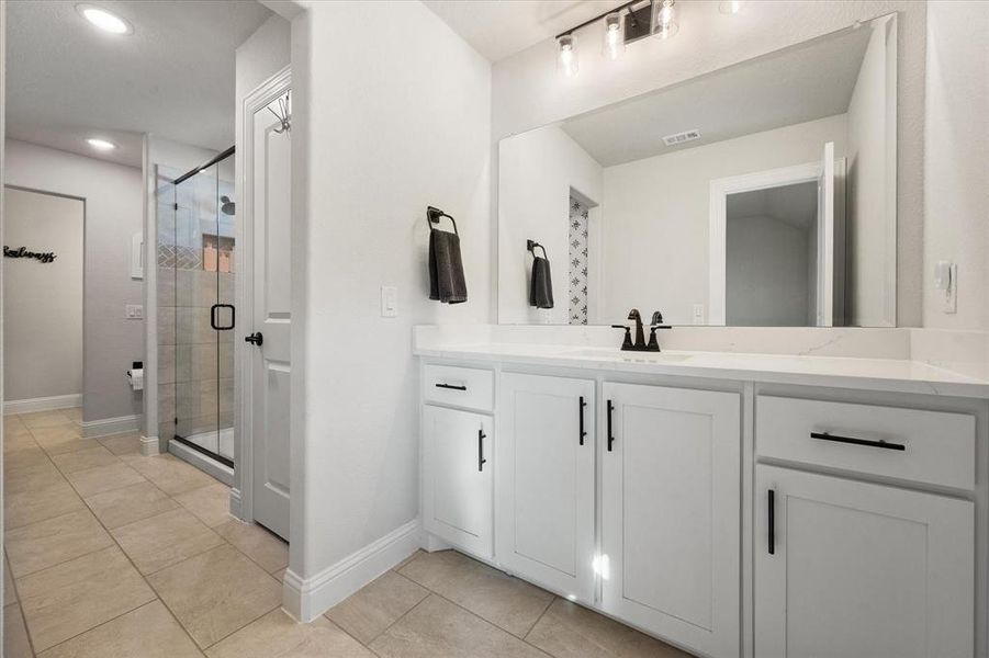 Full bathroom with a shower stall, vanity, light tile patterned floors, and recessed lighting