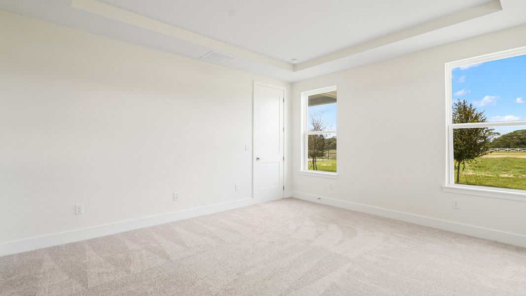 The Sweetgum Spacious and Bright first floor primary suite with large walk-in closet at Trailside in Mount Dora by DRB Homes