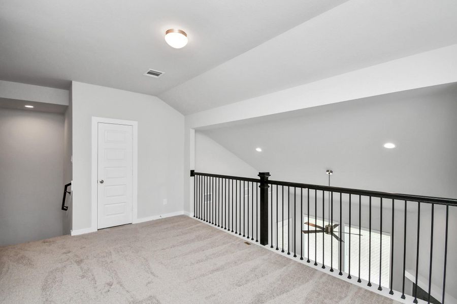 Discover a haven of leisure in this fantastic game room! Whether you're seeking a casual hangout or an adult gaming retreat, this space has it all. Enjoy the luxurious feel of plush carpet underfoot, the expansive ambiance of high ceilings, custom paint that adds a touch of personality, and windows that flood the room with refreshing natural light. Sample photo of completed home with similar floor plan. Actual colors and selections may vary.