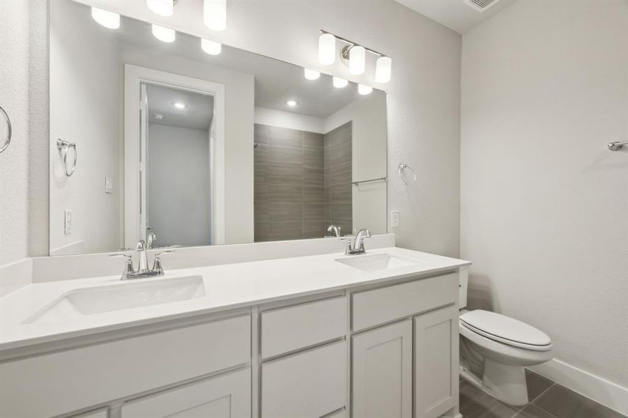 Bathroom with vanity, toilet, tile patterned flooring, and a shower