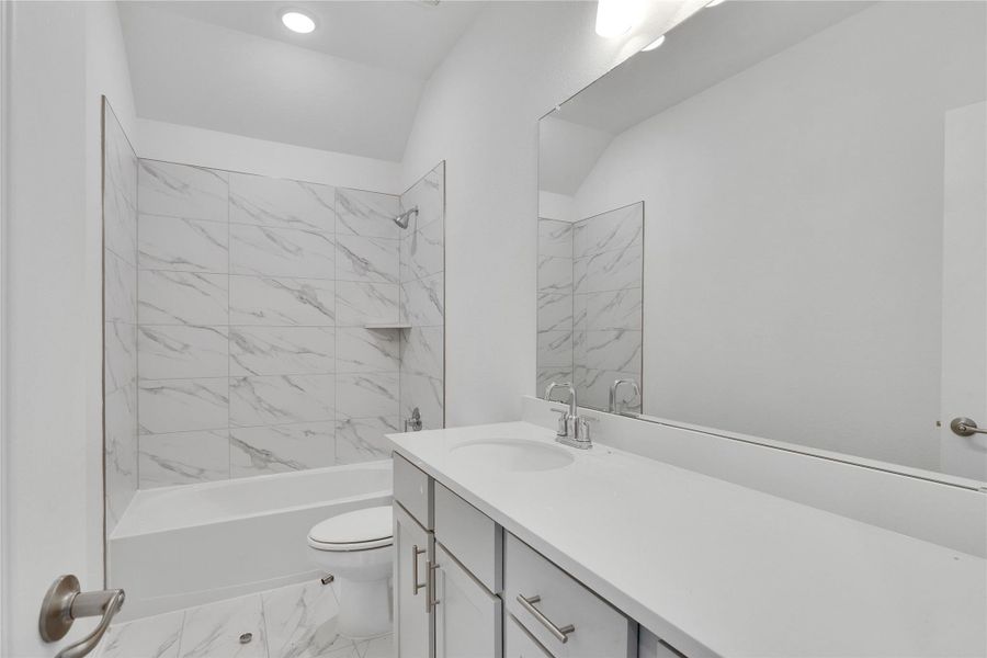 Full bath with vanity, bathing tub / shower combination, and light marble finish floors Full bath with vanity, bathing tub / shower combination, and light marble finish floors