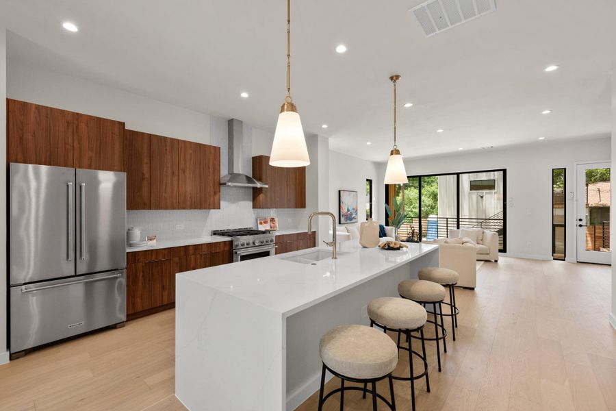 An open-concept living space with a pristine island kitchen and a bright, airy ambiance. An open-concept living space with a pristine island kitchen and a bright, airy ambiance.