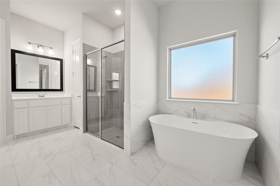 Full bathroom with light marble finish floors, a soaking tub, vanity, a shower stall, and a wainscoted wall