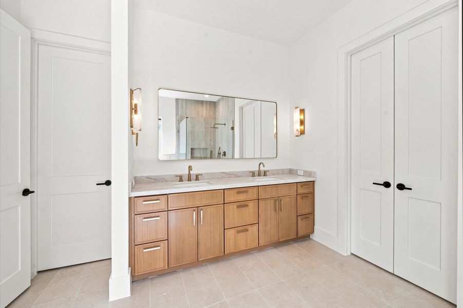 White oak cabinetry and quartz countertops enhance the vanity in the primary bathroom.