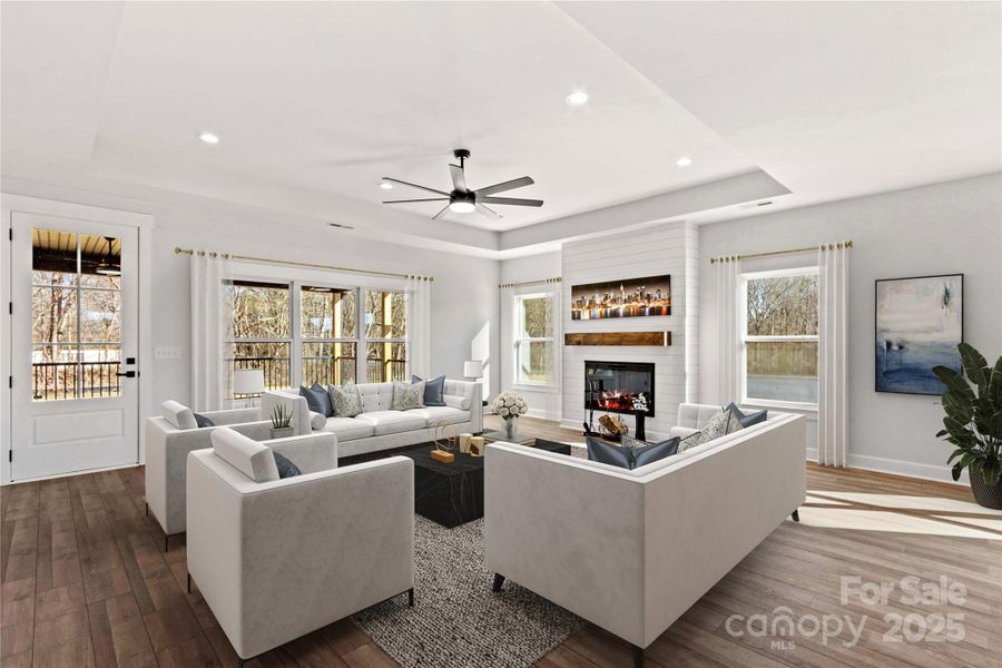 Grand Family Room with 10 foot tray ceiling. ship lap electric fireplace & tons of natural light.