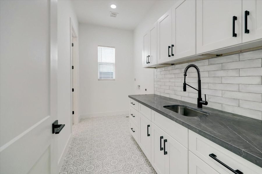 Utility Room – features custom built-ins and a utility sink, along with dual access from both the hallway and the primary closet.