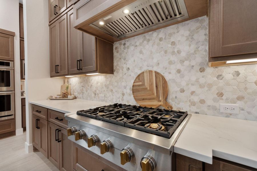 Equipped with top-of-the-line stainless steel appliances, including double ovens, a six-burner gas cooktop, and a designer vent hood, this kitchen is perfect for home chefs. Equipped with top-of-the-line stainless steel appliances, including double ovens, a six-burner gas cooktop, and a designer vent hood, this kitchen is perfect for home chefs.