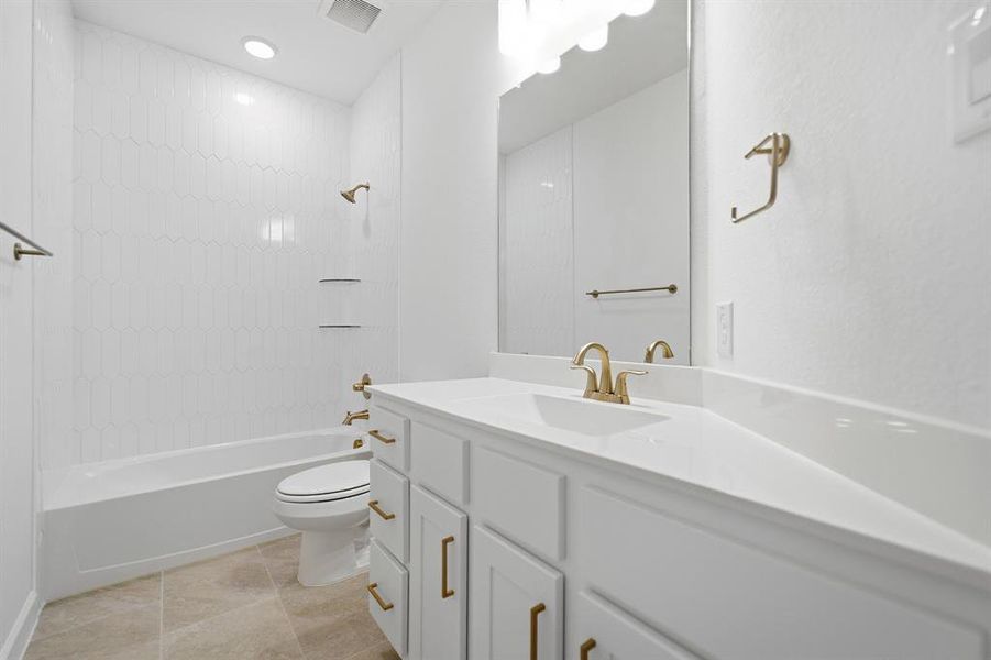Bathroom featuring a tub/shower combination with white picket tile surround, a single vanity with a white countertop, and gold-toned fixtures Bathroom featuring a tub/shower combination with white picket tile surround, a single vanity with a white countertop, and gold-toned fixtures