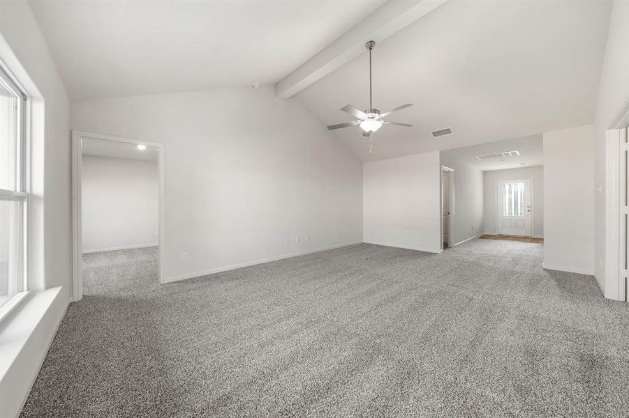 Unfurnished room featuring vaulted ceiling with beams, light carpet, and ceiling fan