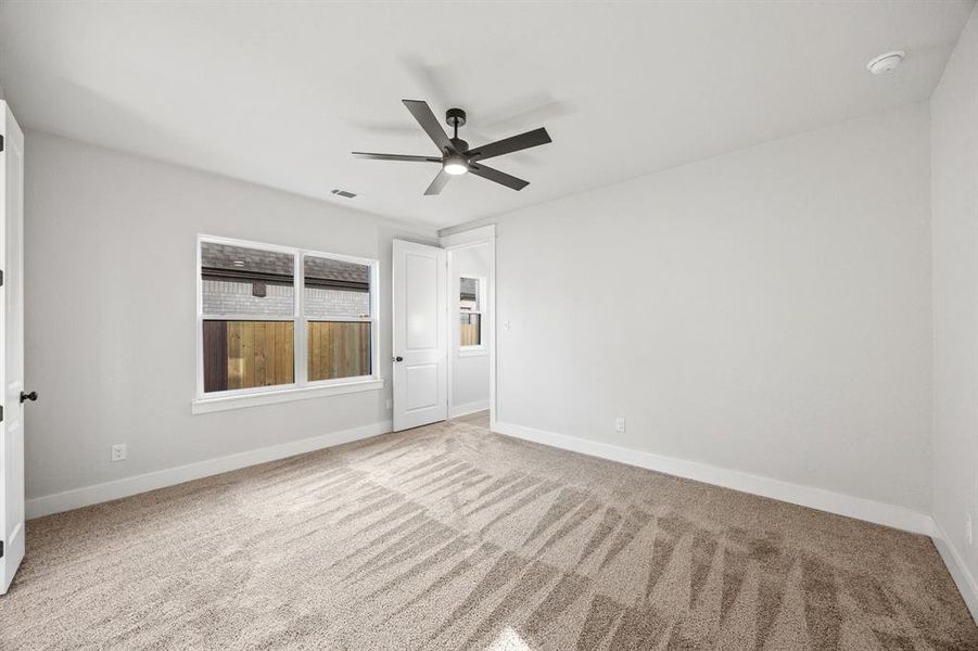 Carpeted spare room with baseboards and a ceiling fan