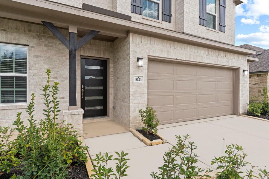 Inviting front elevation showcasing full brick exterior on both levels, stylish entry details, and manicured greenery that adds a touch of warmth and elegance. Inviting front elevation showcasing full brick exterior on both levels, stylish entry details, and manicured greenery that adds a touch of warmth and elegance.