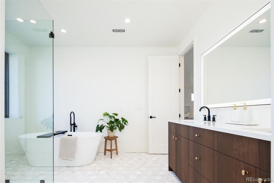 Primary bathroom with custom, dual vanity and freestanding tub