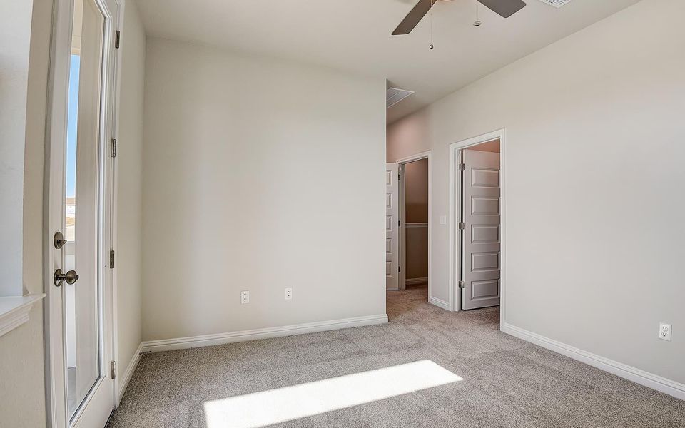 Unfurnished bedroom with light colored carpet and ceiling fan