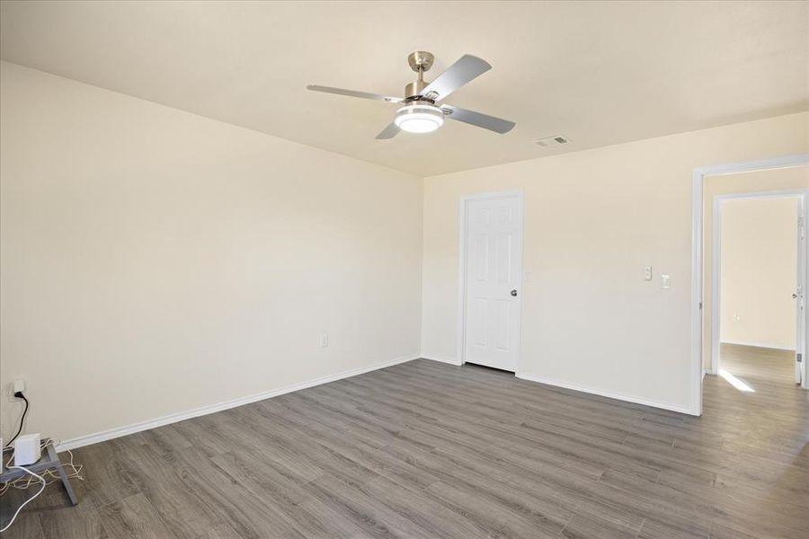 Empty room with dark hardwood / wood-style floors and ceiling fan