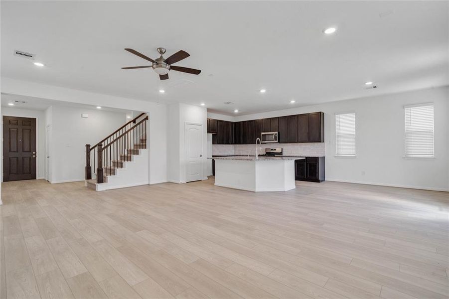 Another view of the great room looking to the kitchen, dining/breakfast areas, and staircase to second floor.