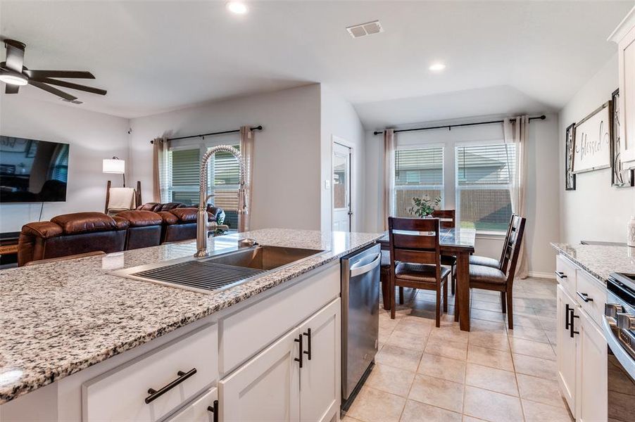 Kitchen featuring white cabinetry, plenty of natural light, recessed lighting, light stone counters, and light tile patterned flooring