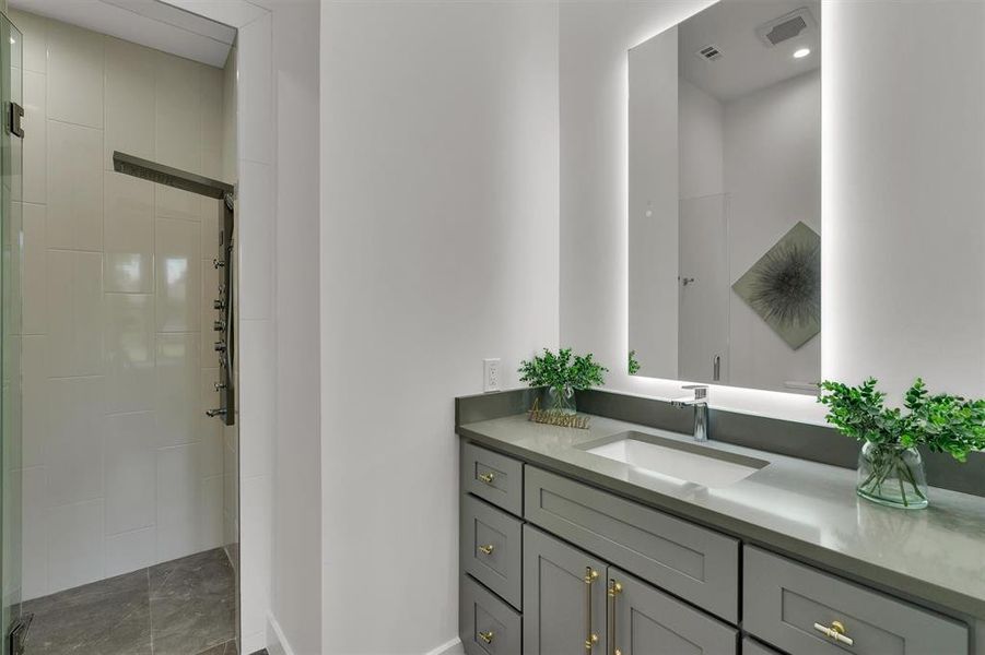 Bathroom featuring vanity and a shower with door