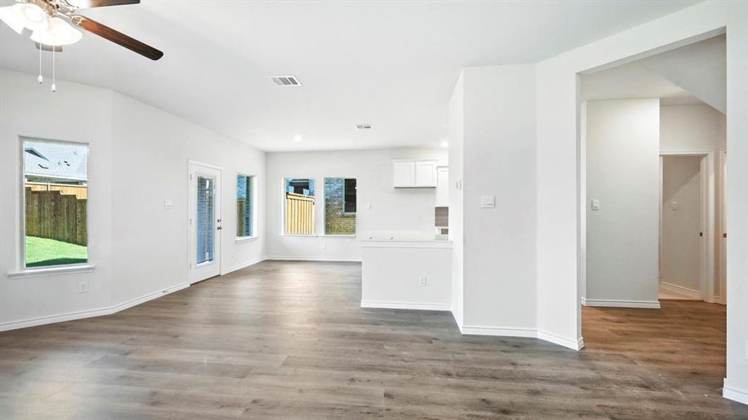Unfurnished living room with dark wood finished floors and a ceiling fan