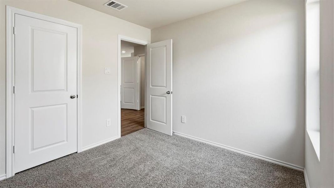 Unfurnished bedroom featuring carpet and baseboards