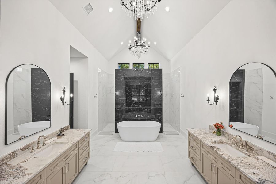 A truly exquisite spa-inspired primary bath with dramatic marble accents, dual vanities, and a centerpiece soaking tub. A truly exquisite spa-inspired primary bath with dramatic marble accents, dual vanities, and a centerpiece soaking tub.