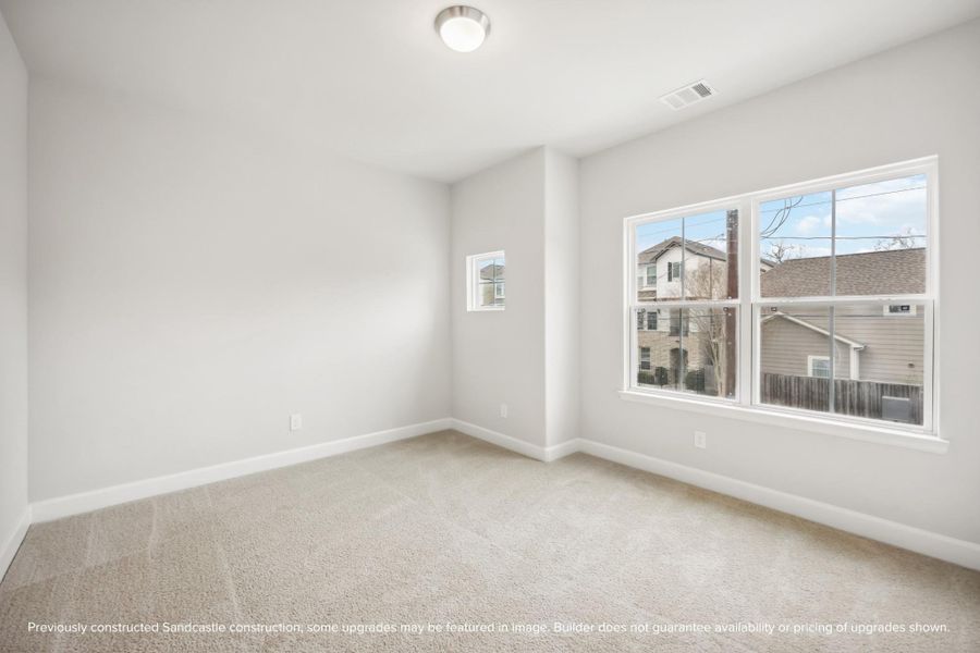 Light and spacious, this larger secondary bedroom at the front of the house shines.