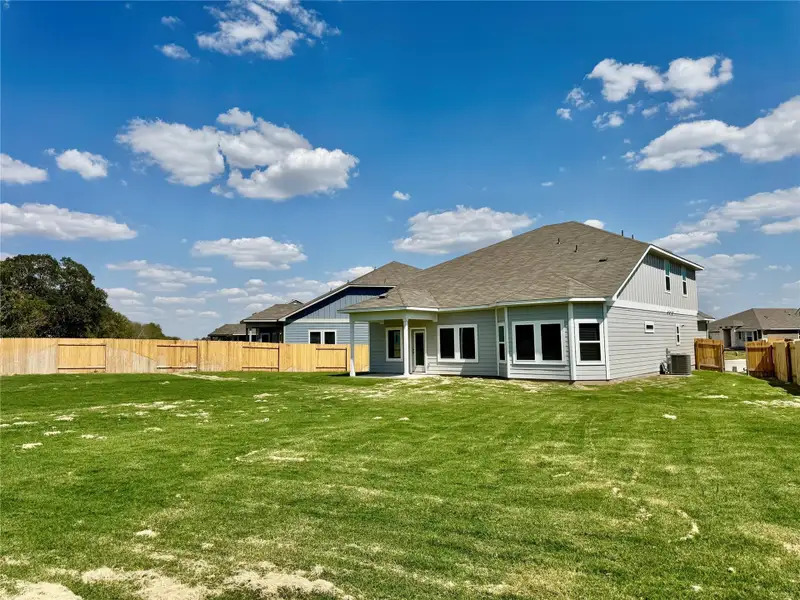 Rear view of property with a patio and roof with shingles