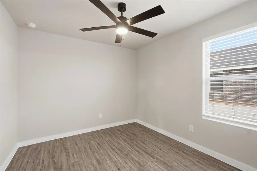 Unfurnished room with wood finished floors and a ceiling fan